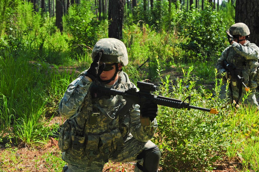 U.S. Air Force Senior Airman Zachary Walker, 23rd Security Forces Squadron patrolman, gives the signal for the team to move into position and prepare to engage opposing forces during a phase II operational readiness exercise at Moody Air Force Base, Ga., Aug. 17, 2011. The 23rd SFS members operated in three different groups while scanning for opposing forces. (U.S. Air Force photo by Senior Airman Stephanie Mancha/Released)