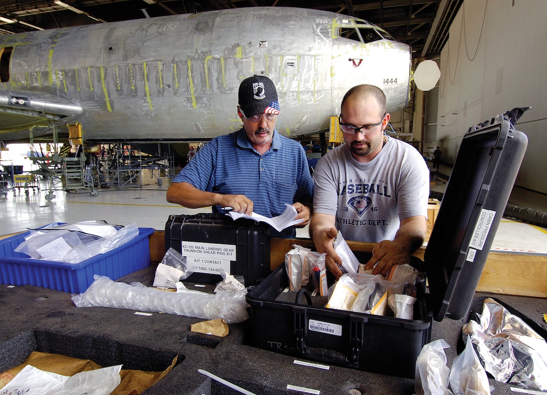 Tinker aircraft work leader Russell Parris, left, and material expeditor Wesley Hugert look througha KC-135 super kit in the 564th Air Craft Maintenance Squadron Inspection Dock located in Bldg. 3102. The kit was a time-saving solution that slashes days from production and improves mechanics' work flow by having parts ready and waiting for the aircraft's arrival. Three such kits are used in the docks with another, always ready to go, said Mr. Hubert who helps build them. "Before, we had to wait for a part and hope what you needed came in because we couldn't order parts early," said Mr. Paris. "Now the kits are built and waiting on the aircraft from day one," KC-135 Program Depot Maintenance Production improvements like this helped the Oklahoma City Air Logistics Center earn the 2011 Robert T. Mason Depot Maintenance Excellence Award. (Air Force Photo by Margo Wright)

