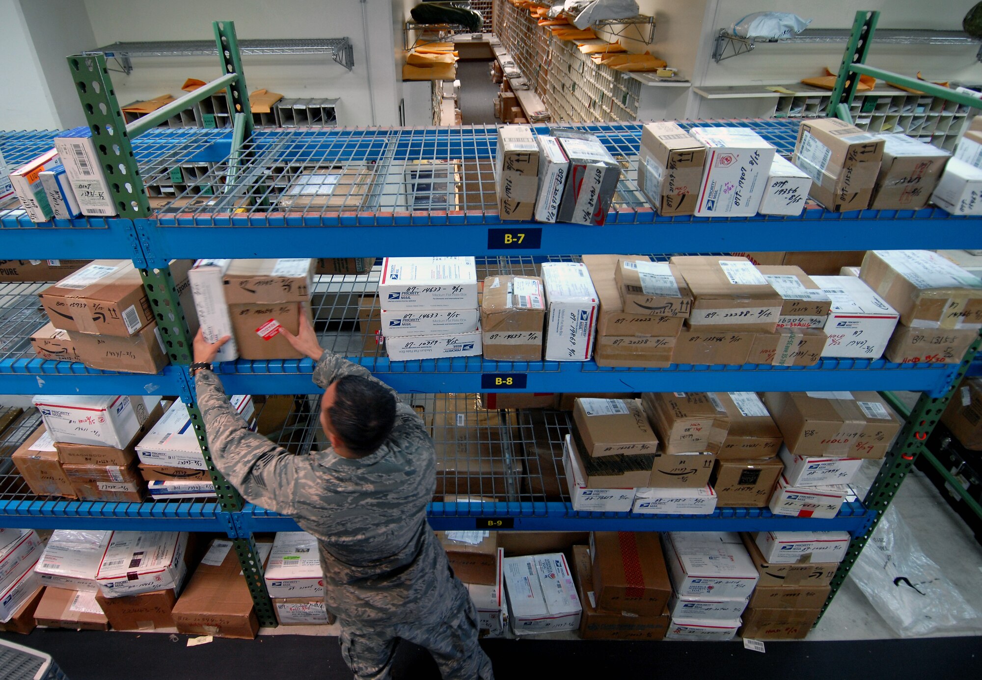 Staff Sgt. James Wong, a postal specialist with the 18th Communications Squadron, arranges packages inside the base post office Aug. 17 at Kadena Air Base, Japan. Members of the Kadena post office have been working around the clock since Typhoon Muifa delayed thousands of pieces of mail from getting to the base. They have processed more than 3,805 pieces of Express, Letter-Class, Priority and Space Available mail totaling 83,829.5 lbs since the 60-hour typhoon.  “The active duty Airmen and local nationals of the post office strive to process and deliver mail to Team Kadena within 24 hours of receiving mail trucks,” said Wong. “The post office receives two to three trucks of mail on a daily basis.” (U.S. Air Force photo/Senior Airman Sara Csurilla)
