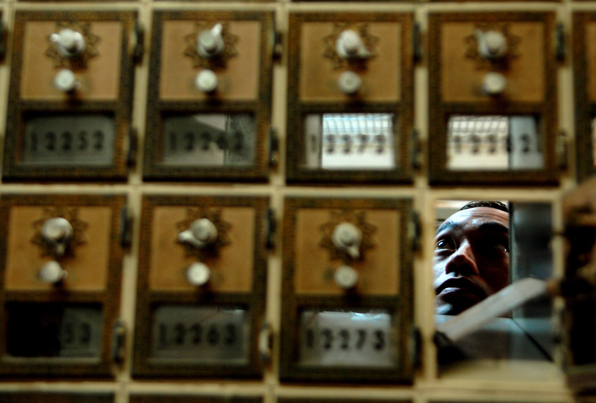 Staff Sgt. James Wong, a postal specialist with the 18th Communications Squadron, puts mail into members of Team Kadena’s mail boxes at the base post office Aug. 17 at Kadena Air Base, Japan. Members of the Kadena post office have been working around the clock since Typhoon Muifa delayed thousands of pieces of mail from getting to the base. They have processed more than 3,805 pieces of Express, Letter-Class, Priority and Space Available mail totaling 83,829.5 lbs since the 60-hour typhoon. "The active duty Airmen and local nationals of the post office strive to process and deliver mail to Team Kadena within 24 hours of receiving mail trucks," said Wong. "The post office receives two to three trucks of mail on a daily basis." (U.S. Air Force photo/Senior Airman Sara Csurilla)