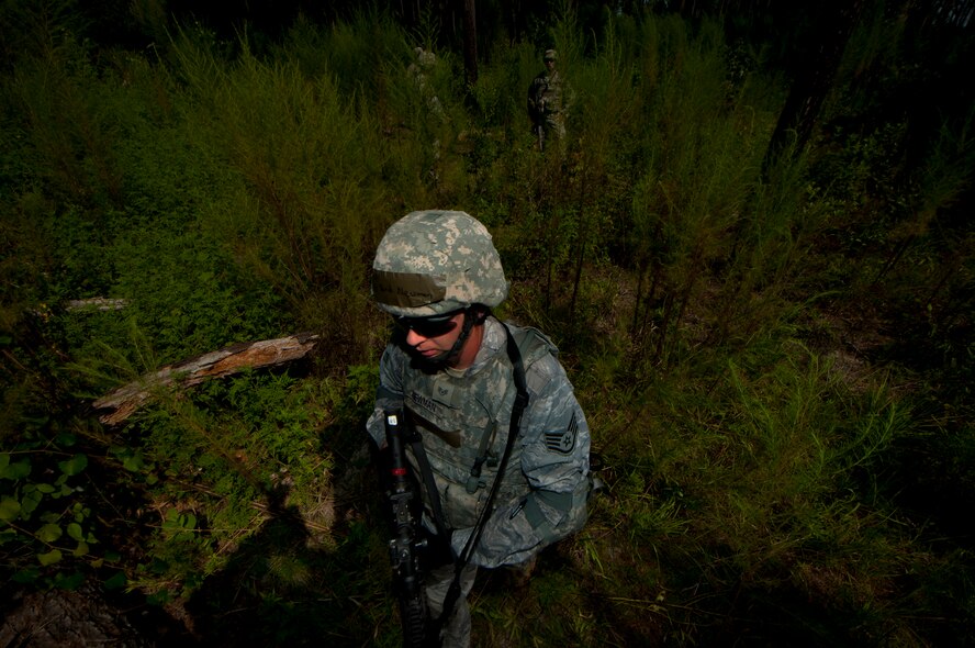 U.S. Air Force Staff Sgt. David Newman, 23rd Security Forces Squadron fireteam member, steps over a log while searching for opposing forces during a phase II operational readiness exercise at Moody Air Force Base, Ga., Aug. 17, 2011. The 23rd SFS Airmen operated in three different groups while scanning and attempting to locate opposing forces. (U.S. Air Force photo by Airman 1st Class Joshua Green/Released)
