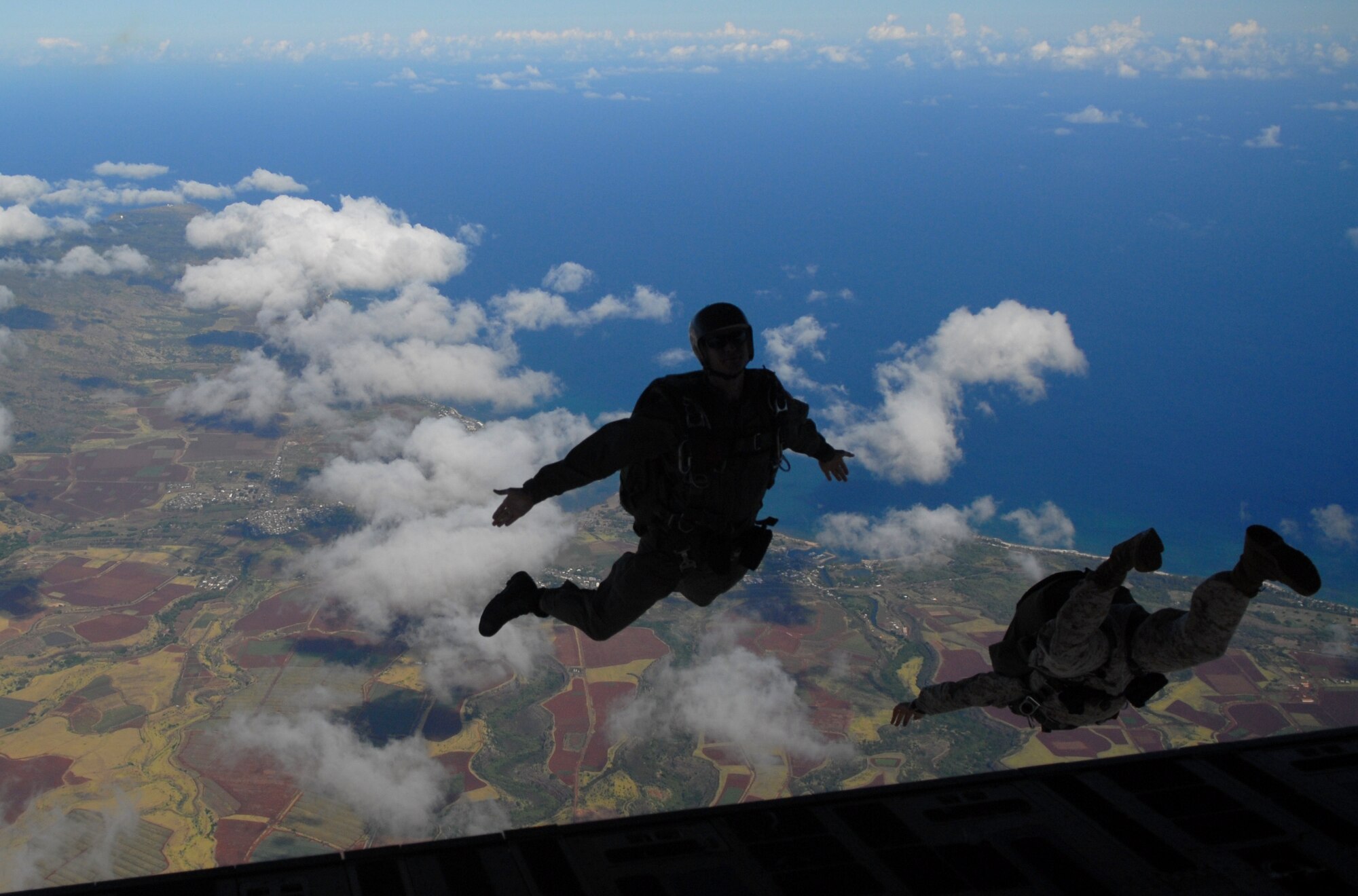 U.S. Army Chief Warrant Officer 4 Orlando Villegas, a staff officer from the Special Operations Command, Pacific, jumps out of a 535th Airlift Squadron C-17 over Hawaii skies Aug. 11. Villegas, 32 other Soldiers, and a Marine from Camp Smith, Hawaii, performed static and HALO (high altitude-low opening) jumps to maintain proficiency and currency during an orientation flight for the new commander at Joint Base Pearl Harbor-Hickam, Hawaii. (U.S. Air Force photo/Staff Sgt. Carolyn Herrick)