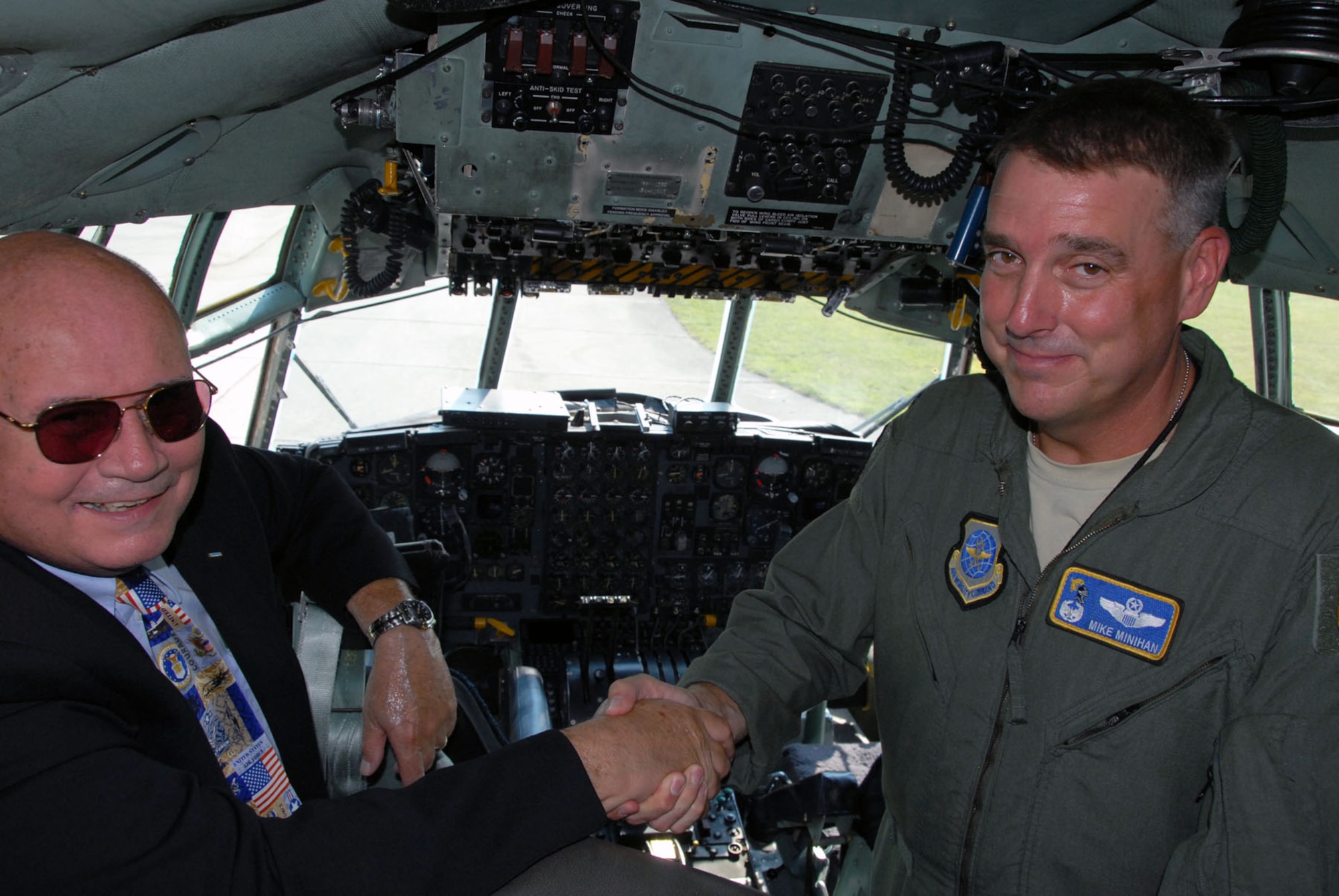 DAYTON, Ohio -- C-130E SPARE 617 made its final flight to the National Museum of the U.S. Air Force on Aug. 18, 2011. Here, Col. Michael A. Minihan, commander of the 19th Airlift Wing, shakes hands with Col. (Ret.) William Caldwell, who received the Air Force Cross while piloting the aircraft during the Southeast Asia War. (U.S. Air Force photo by Jeff Fisher)