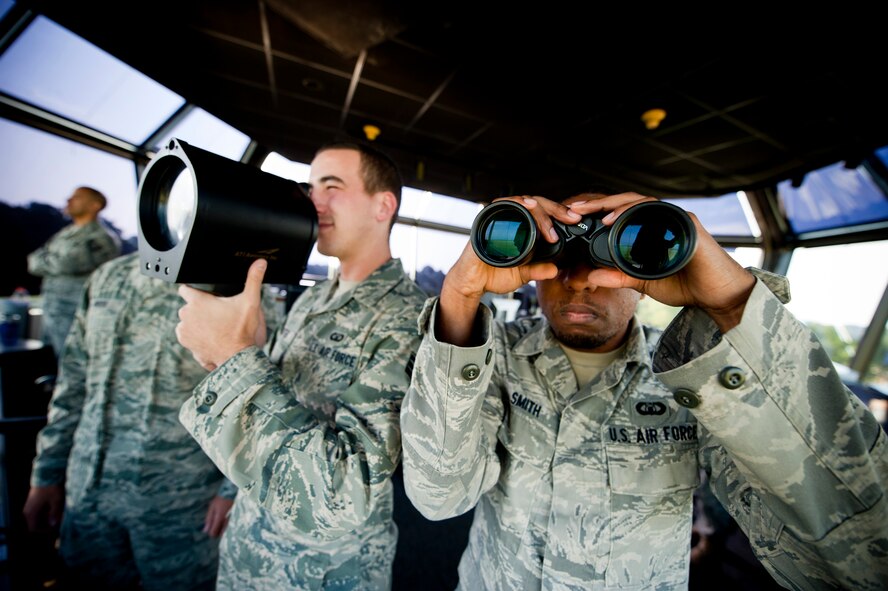 U.S. Air Force Senior Airmen Michael Zientek, left, and Darnell Smith, 23rd Operations Support Squadron air traffic controllers (ATC) and trainers, simulate their capabilities at Moody Air Force Base, Ga., Aug. 18, 2011. ATCs are responsible for keeping a watchful eye on the flight line and ensuring the safety of pilots flying aircraft within a five-mile radius of Moody. (U.S. Air Force photo by Staff Sgt. Jamal D. Sutter/Released)