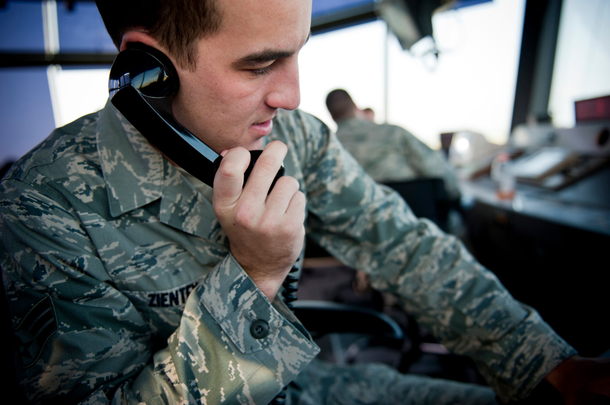 U.S. Air Force Senior Airman Michael Zientek, 23rd Operations Support Squadron air traffic controller (ATC) and trainer, discusses flight operations with another base agency at Moody Air Force Base, Ga., Aug. 18, 2011. ATCs constantly communicate with units such as the radar approach control, maintenance operations center and weather flight. In the event of an emergency, they also have ways of communicating with all key organizations and first responders at once. (U.S. Air Force photo by Staff Sgt. Jamal D. Sutter/Released)