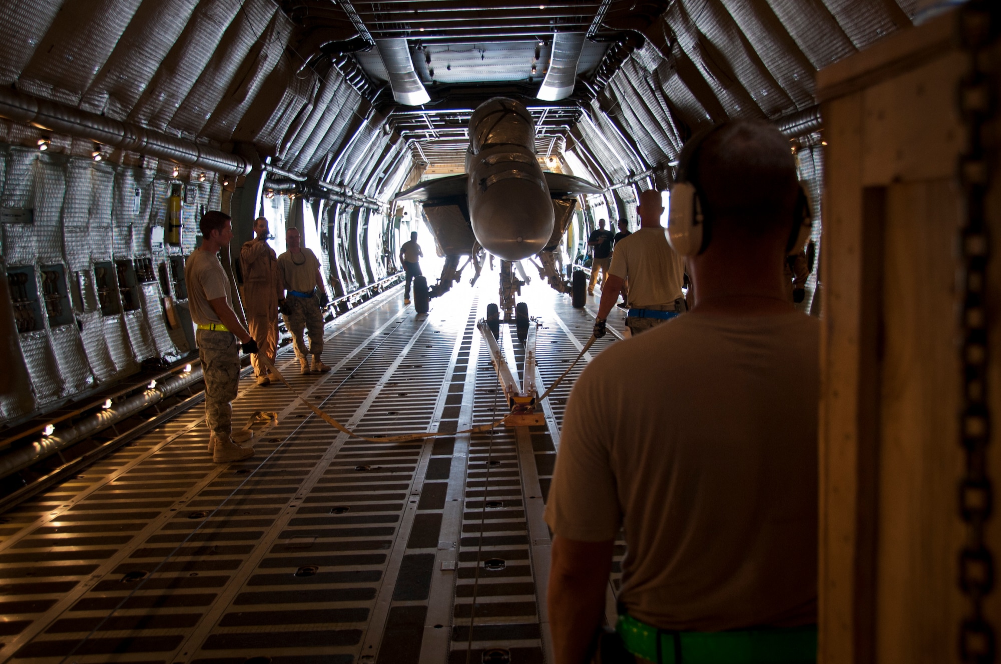 KANDAHAR AIRFIELD, Afghanistan -- Members of the 451st Expeditionary Logistics Readiness Squadron aerial port flight and 22nd Airlift Squadron prepare to load an F/A-18 Super Hornet onto a C-5 Galaxy here Aug. 18, 2011. This marked the first time the C-5 had been used to transport the F/A-18 back to the United States. After months of coordination and planning, senior leaders at the Navy’s Naval Air Forces and the Air Force’s Air Mobility Command approved a plan to transport the aircraft back to its home station at Naval Air Station North Island near San Diego, Calif. (U.S. Air Force photo by Senior Airman David Carbajal)