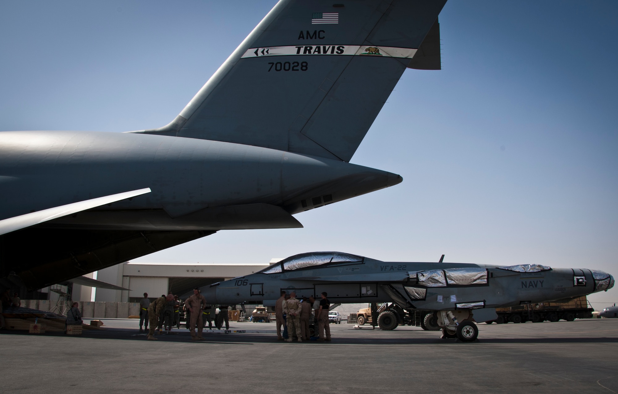 KANDAHAR AIRFIELD, Afghanistan -- Members of the 451st Expeditionary Logistics Readiness Squadron aerial port flight and 22nd Airlift Squadron prepare to load an F/A-18 Super Hornet onto a C-5 Galaxy here Aug. 18, 2011. This marked the first time the C-5 had been used to transport the F/A-18 back to the United States.  After months of coordination and planning, senior leaders at the Navy’s Naval Air Forces and the Air Force’s Air Mobility Command approved a plan to transport the aircraft back to its home station at Naval Air Station North Island near San Diego, Calif. (U.S. Air Force photo by Senior Airman David Carbajal)
