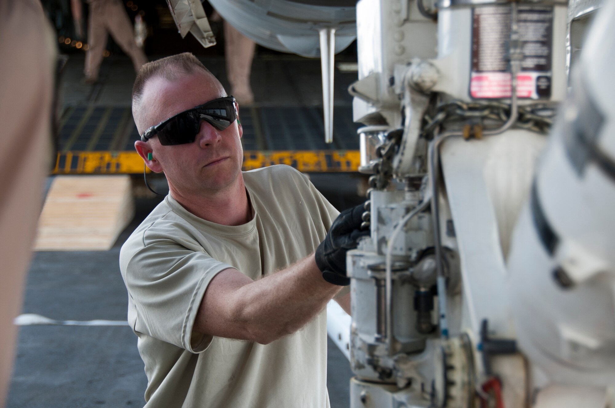 KANDAHAR AIRFIELD, Afghanistan -- Master Sgt. Raymond Sambor, 451st Expeditionary Logistics Readiness Squadron aerial port duty officer, attaches a loading chain onto an F/118 Super Hornet here Aug. 18, 2011. Sambor and several members of the 451st ELRS aerial port assisted the load of an F/A-18 Super Hornet onto a C-5 Galaxy. This marked the first time the C-5 had been used to transport the F/A-18 back to the United States.  After months of coordination and planning, senior leaders at the Navy’s Naval Air Forces and the Air Force’s Air Mobility Command approved a plan to transport the aircraft back to its home station at Naval Air Station North Island near San Diego, Calif. (U.S. Air Force photo by Senior Airman David Carbajal)