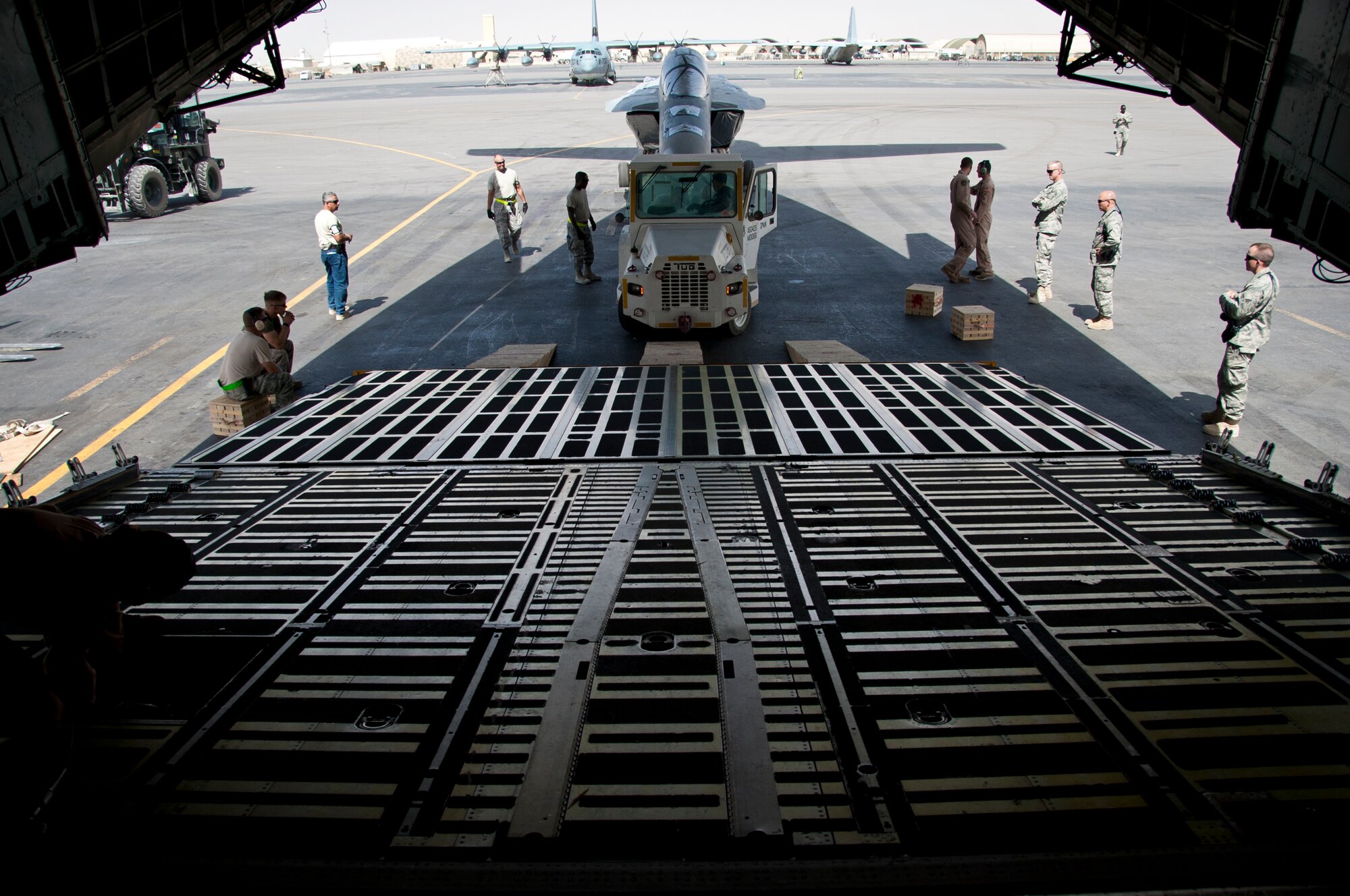 KANDAHAR AIRFIELD, Afghanistan -- Members of the 451st Expeditionary Logistics Readiness Squadron aerial port flight and 22nd Airlift Squadron prepare to load an F/A-18 Super Hornet onto a C-5 Galaxy here Aug. 18, 2011. This marked the first time the C-5 had been used to transport the F/A-18 back to the United States.  After months of coordination and planning, senior leaders at the Navy’s Naval Air Forces and the Air Force’s Air Mobility Command approved a plan to transport the aircraft back to its home station at Naval Air Station North Island near San Diego, Calif. (U.S. Air Force photo by Senior Airman David Carbajal)