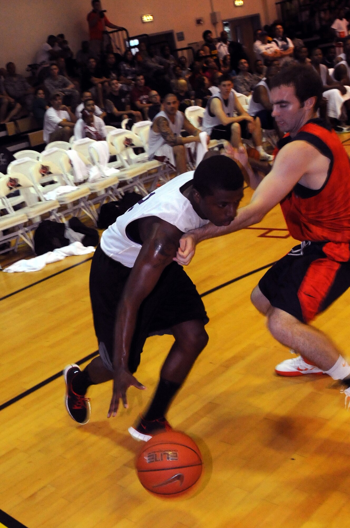 Aviano Air Base Guard Travis Moon dribbles past Illinois University guard Kevin Berardini during an exhibition game Aug. 17 at the Dragon Fitness Center. Basketball players from both Illinois and West Virginia University showed Aviano Airmen and families their moves during a multiple session scrimmage as part of their tour in Italy. (U.S. Air Force photo/Airman LaVel Sterling)