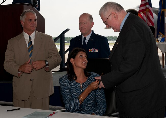 South Carolina Governor Nikki Haley presents retired Navy Rear Adm.James Carey one of the pens she used to sign the Overseas Citizens Absentee Voters Act  at Joint Base Charleston Aug. 17. Also pictured are South Carolina Senator Chip Campsen and Brig. Gen. Grady Patterson. Patterson is the assistant adjutant general for South Carolina National Guard and Carey is the senior policy advisor to the Pew Center on the states.  (U.S. Air Force photo/Staff Sgt. Katie Gieratz)