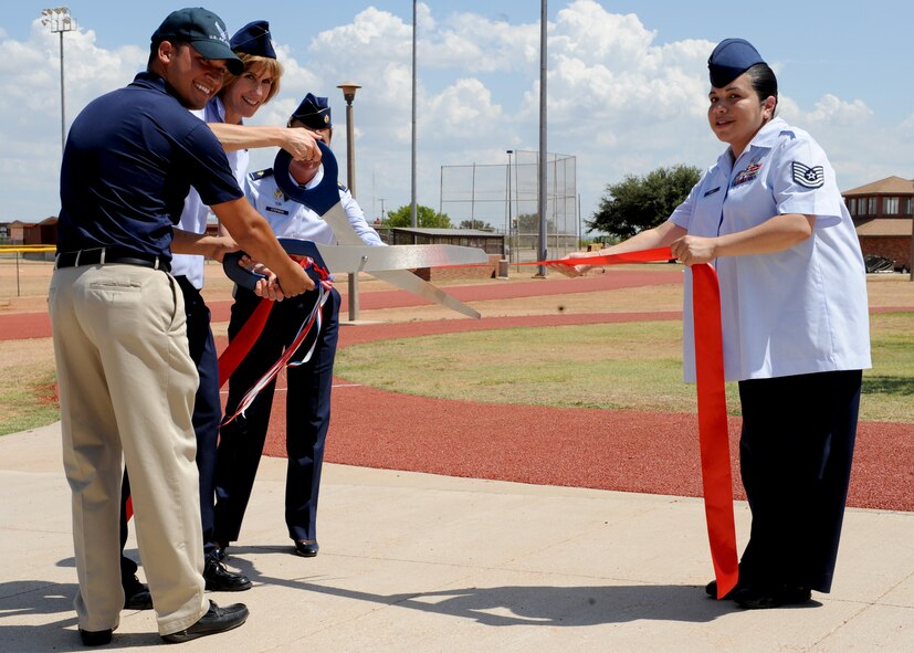Airman 1st Class Joseph Kay, 7th Force Support Squadron, and Lt. Col. Kristina O’Brien, 7th Mission Support Group commander, cut a ribbon Aug. 15, 2011 marking the re-opening of numerous fitness center facilities at Dyess Air Force Base, Texas. The re-opening consisted of renovations to the mile-long track, football field and gymnasium. (U.S. Air Force photo by Airman 1st Class Jonathan Stefanko/ Released) 