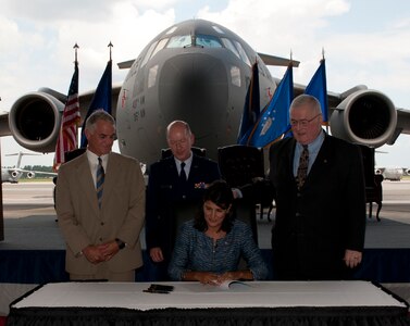 South Carolina Governor Nikki Haley prepares to ceremoniously sign the Overseas Citizens Absentee Voters Act at Joint Base Charleston Aug. 17, as South Carolina Senator Chip Campsen, Brig. Gen. Grady Patterson and retired Navy Rear Adm. James Carey look on. Patterson is the assistant adjutant general for South Carolina National Guard and Carey is the senior policy advisor to the Pew Center on the states. (U.S. Air Force photo/Staff Sgt. Katie Gieratz)
