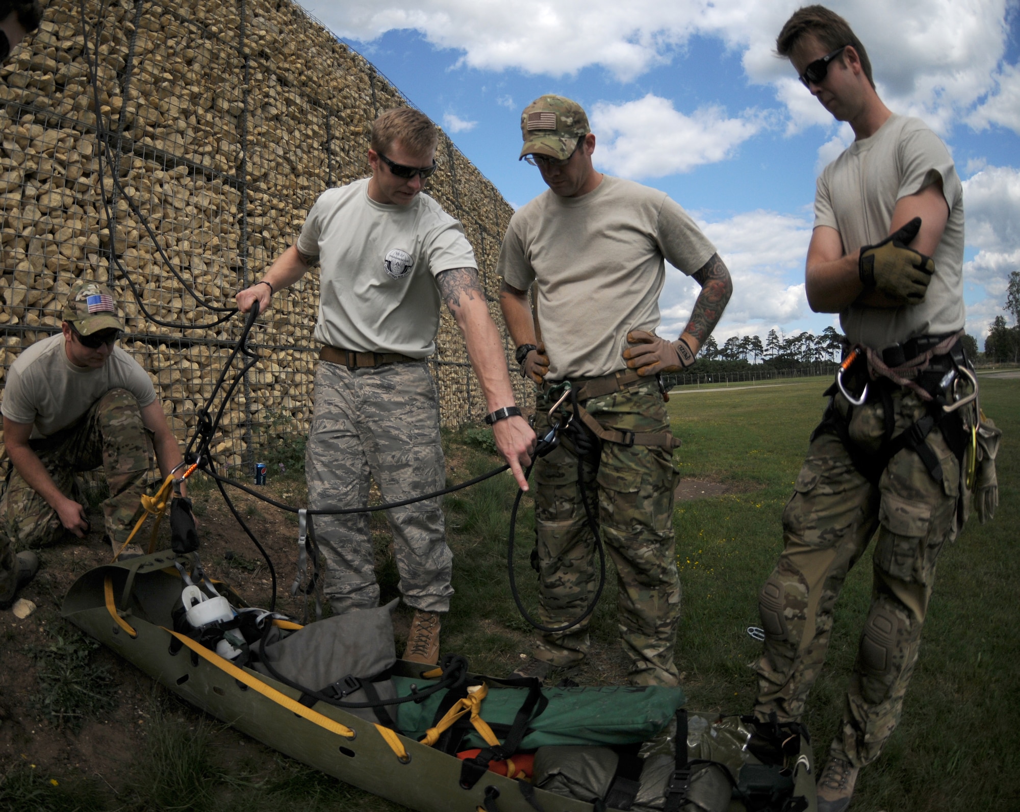 ROYAL AIR FORCE LAKENHEATH, England - Staff Sgt. Issaiah McPheron (second from left), 56th Rescue Squadron pararescueman, explains how to safely transport a patient to Staff Sgts. Jeremy French and Muhoni Gibson, 56th RQS pararesecuemen, during mountain rescue training on RAF Lakenheath, Aug. 15, 2011. Pararesecuemen must train to recover and safely remove patients from any situation, time or place. The 56th RQS is a combat-ready search and rescue squadron of HH-60G Pave Hawk helicopters capable of executing all-weather search and rescue missions day or night in hostile environments. (U.S. Air Force photo/Airman Cory Payne)