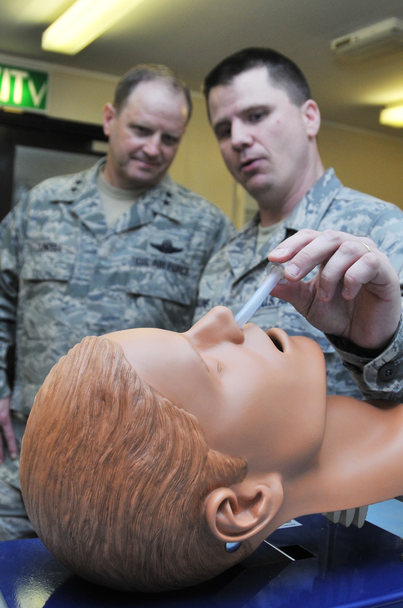 ROYAL AIR FORCE LAKENHEATH, England –Tech. Sgt. Victor Malone, 48th Medical Group simulation and life support program manager, shows Maj. Gen. Jay Lindell (left), Headquarters U.S. Air Force, Washington, D.C., Global Power Programs director, Office of the Assistant Secretary of the Air Force for Acquisition, how to insert a nasal pharyngeal airway tube into a mannequin Aug. 12, 2011. Lindell toured the medical group and other base facilities to meet with Liberty Wing Airmen. Lindell also attended this year’s combat dining-in as the guest speaker. (U.S. Air Force photo/Senior Airman Lausanne Morgan)