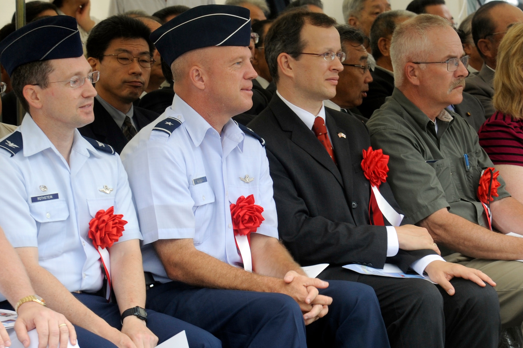 MISAWA, Japan -- Col. Michael Rothstein, left, 35th Fighter Wing commander, and Brig. Gen. John Raymond, left center, 5th Air Force vice commander, listen to opening remarks during the Miss Veedol Flight 80th Anniversary Ceremony held at the Misawa Air and Science Museum Aug. 18. Miss Veedol was the first airplane to fly non-stop across the Pacific Ocean from Sabishiro Beach, Misawa to Wenatchee, Washington. (U.S. Air Force photo/Tech. Sgt. Marie Brown)