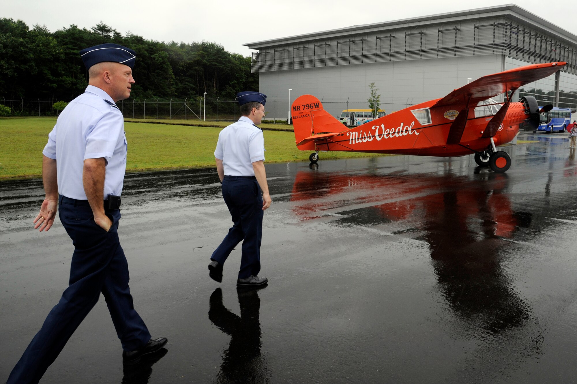 MISAWA, Japan -- Brig. Gen. John Raymond, left, 5th Air Force vice commander, and Col. Michael Rothstein, 35th Fighter Wing commander, walk to a replica of the Miss Veedol, a 1931 Bellanca Skyrocket J-300, prior to the start of the Miss Veedol Flight 80th Anniversary ceremony at Misawa Air and Science Museum Aug 18. Miss Veedol was the first airplane to fly non-stop across the Pacific Ocean from Sabishiro Beach, Misawa to Wenatchee, Washington. (U.S. Air Force photo/Tech. Sgt. Marie Brown)