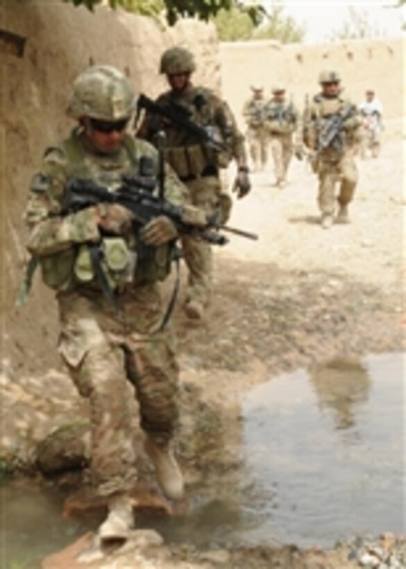U.S. Army Sgt. 1st Class John Shimkus (left), a platoon sergeant with the Kandahar Provincial Reconstruction Team crosses a creek during a dismounted combat patrol in Babur Village, Kandahar province, Afghanistan, on Aug. 13, 2011.  The Kandahar Provincial Reconstruction Team's mission is to improve security, governance and infrastructure capacity throughout the province.  