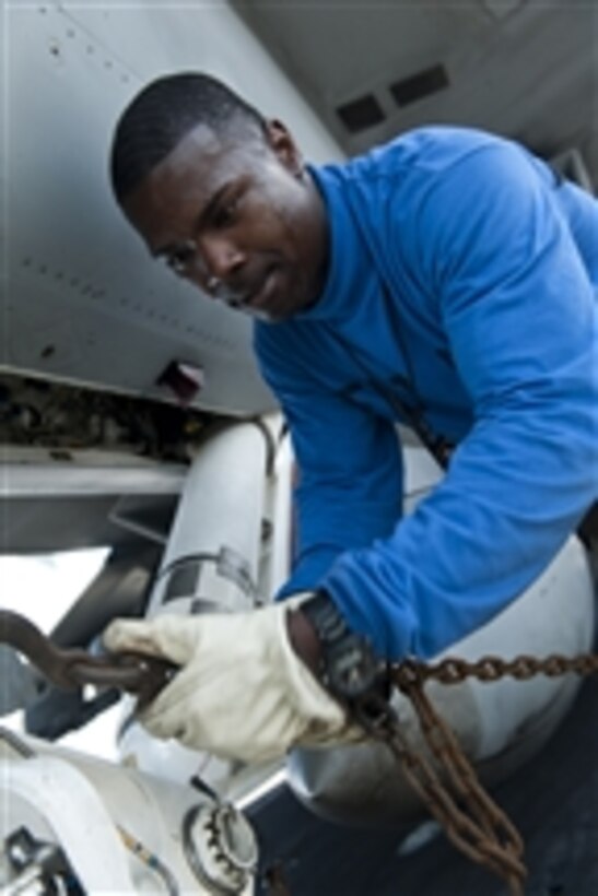 Airman Cameron Brown attaches a chain to an F/A-18F Super Hornet assigned to Strike Fighter Squadron 41 aboard the aircraft carrier USS John C. Stennis (CVN 74) underway in the Pacific Ocean on Aug. 16, 2011.  The John C. Stennis Carrier Strike Group is on a scheduled deployment to the western Pacific Ocean and the Arabian Gulf.  