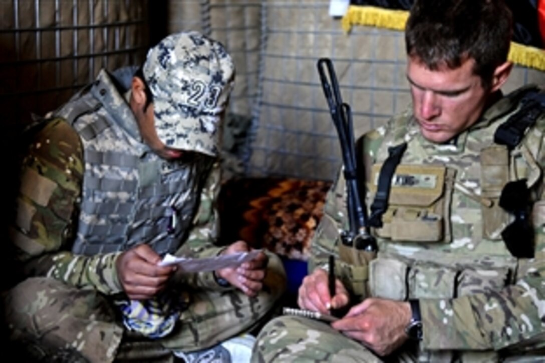 U.S. Navy Lt. Patrick King writes the English translation of a letter left two days prior by enemy insurgents in the village of Khani Kalay in the western Sarobi district of Afghanistan's Paktika province, Aug. 16, 2011. King met with the Afghan police to assist Afghan people in establishing long-term stability and countering insurgents. King is the Paktika Provincial Reconstruction Team Orgun Detachment operations officer.