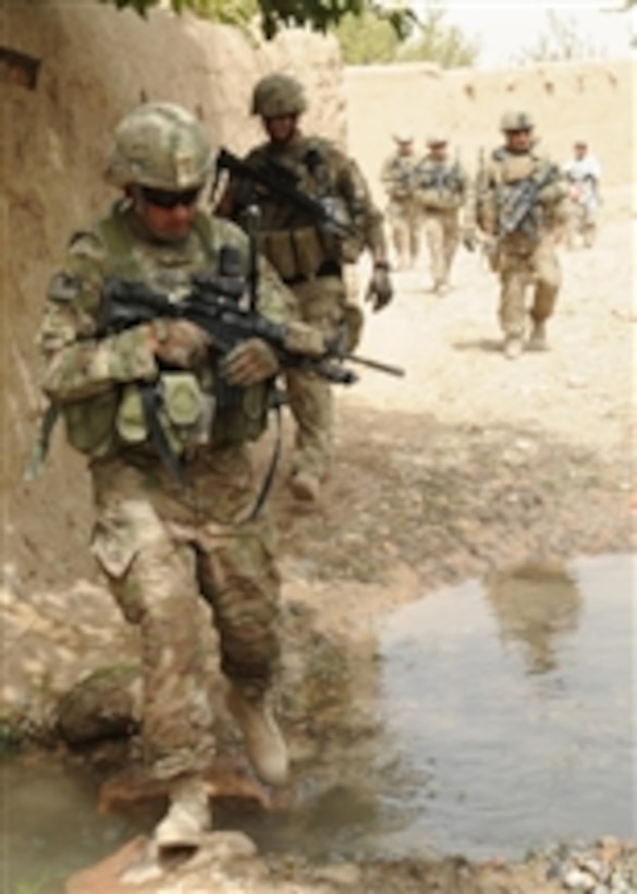 U.S. Army Sgt. 1st Class John Shimkus (left), a platoon sergeant with the Kandahar Provincial Reconstruction Team crosses a creek during a dismounted combat patrol in Babur Village, Kandahar province, Afghanistan, on Aug. 13, 2011.  The Kandahar Provincial Reconstruction Team's mission is to improve security, governance and infrastructure capacity throughout the province.  