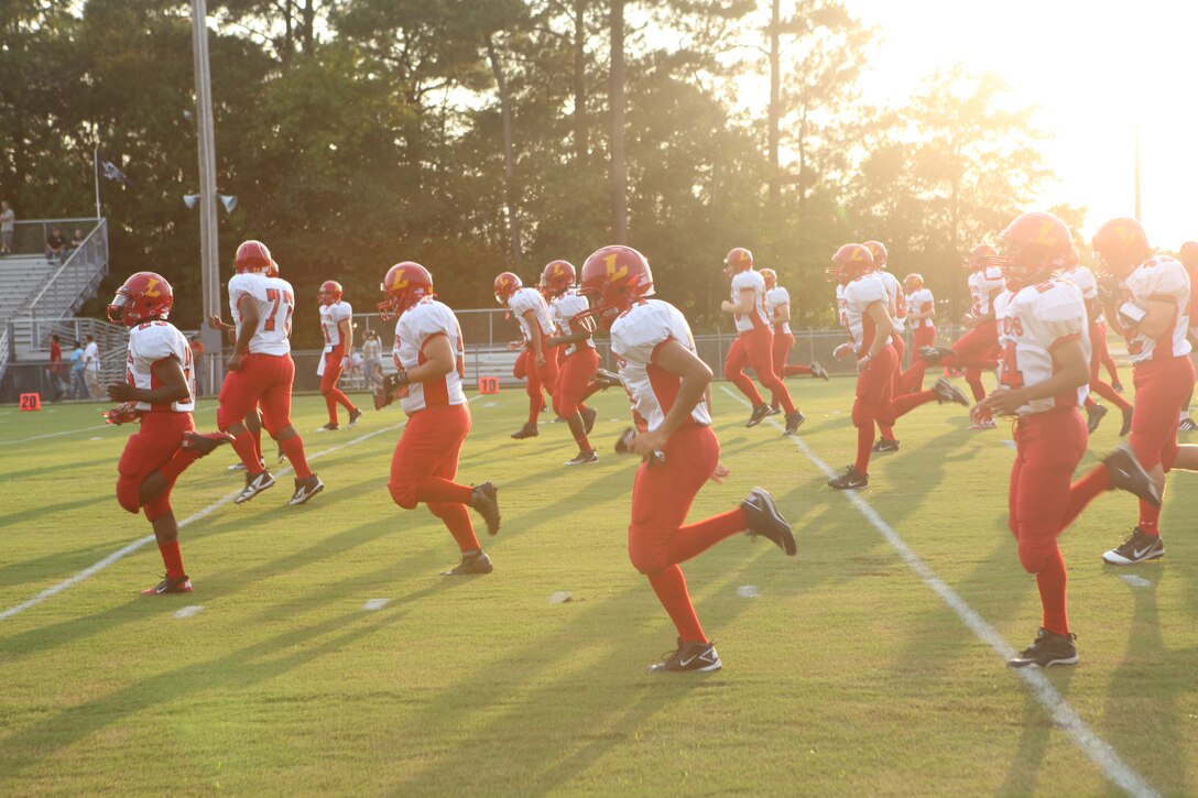 Lejeune High School Devil Pups conduct their warm-ups prior to their season opener at Swansboro High School, Aug. 19. The Devil Pups, who went 2-10 last season, set their expectations high for this season and plan on going above .500 this year. They lost a hard-fought battle against the Swansboro Pirates, 37-28.