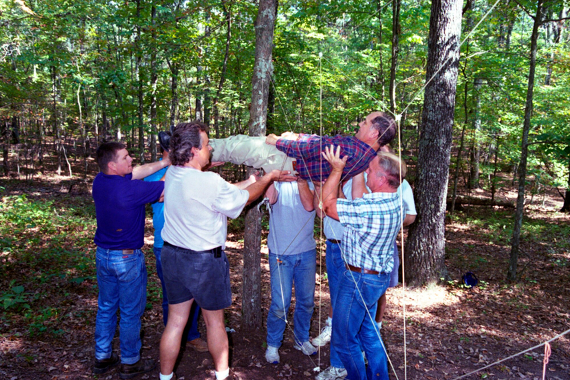 Propulsion Wind Tunnel (PWT) maintenance instrument technicians & electricians maneuver a fellow employee through the Spider Web during an AEDC Ropes Course exercise, Sept. 21, 1994. (Photo provided)