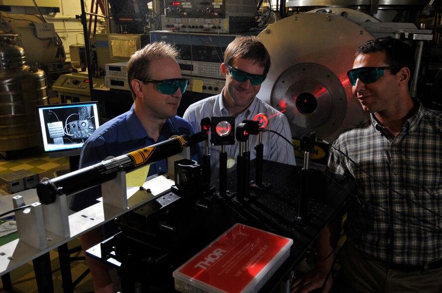 From left, UTSI’s Dr. Trevor Moeller and UTSI graduate students James Rogers and Jesse Labello examine the laser that the research team set up in the lab at AEDC’s Building 1077 to conduct a test on measuring the ice buildup on a mirror as part of a cryo-contamination study for detection and possible mitigation applications. Billy Ring, another UTSI graduate (not pictured) worked on this project as well. (Photo by Rick Goodfriend)