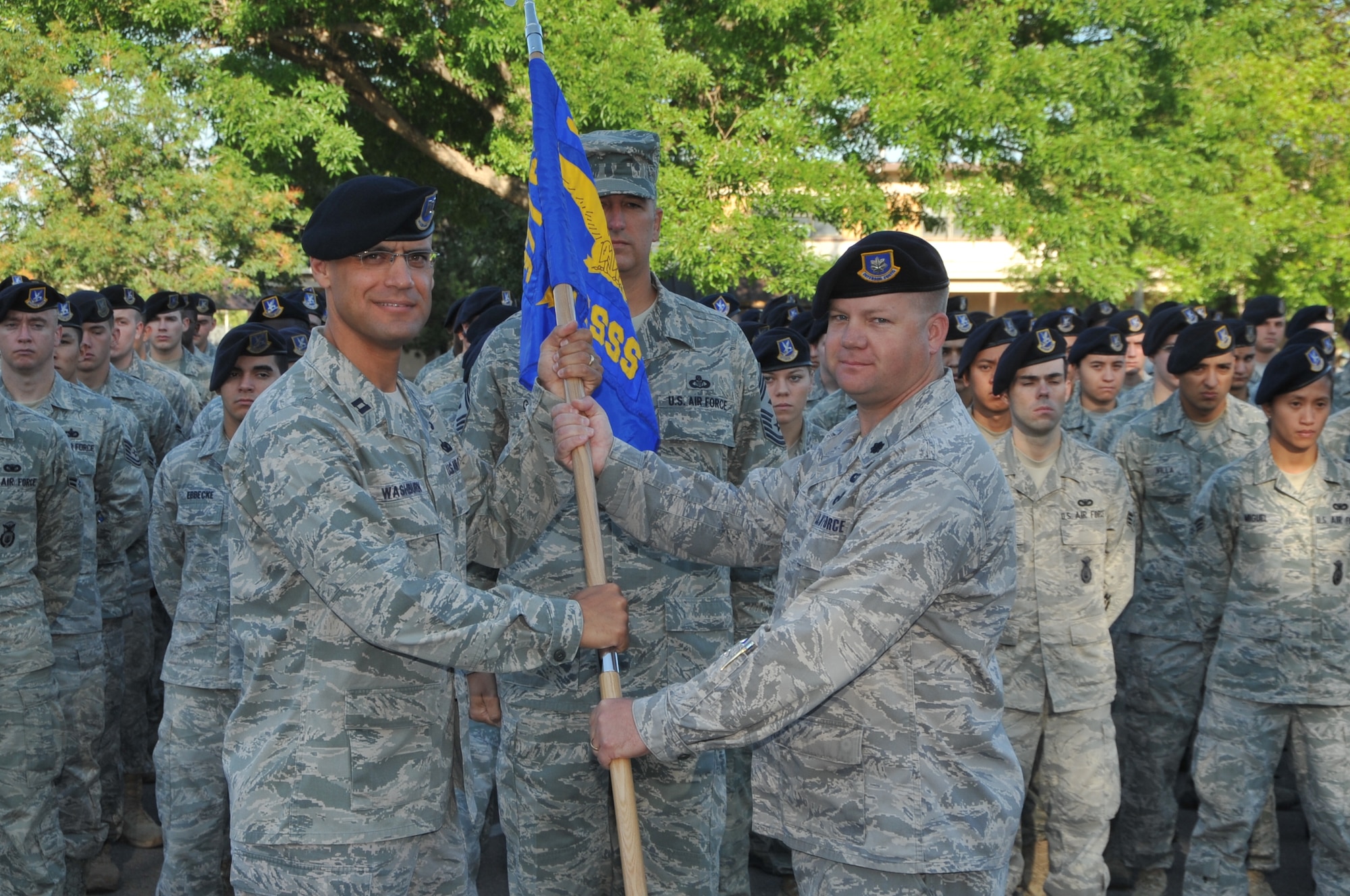 Capt. Benjamin Washburn, the 377th Weapons System Security Squadron commander, left, receives the guidon from Lt. Col. Jason Beers, 377th Security Forces Group commander, during Monday’s reactivation of the 377th Security Forces Group. (photo by Todd Berenger)