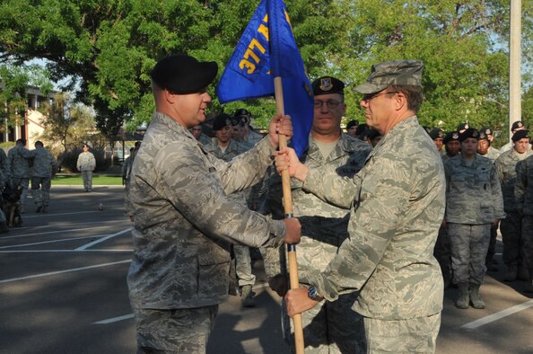 Lt. Col. Jason Beers, 377th Security Forces Group commander, left, receives the unit guidon from Col. Robert L. Maness, 377th Air Base Wing commander, during the reactivation ceremony Monday.