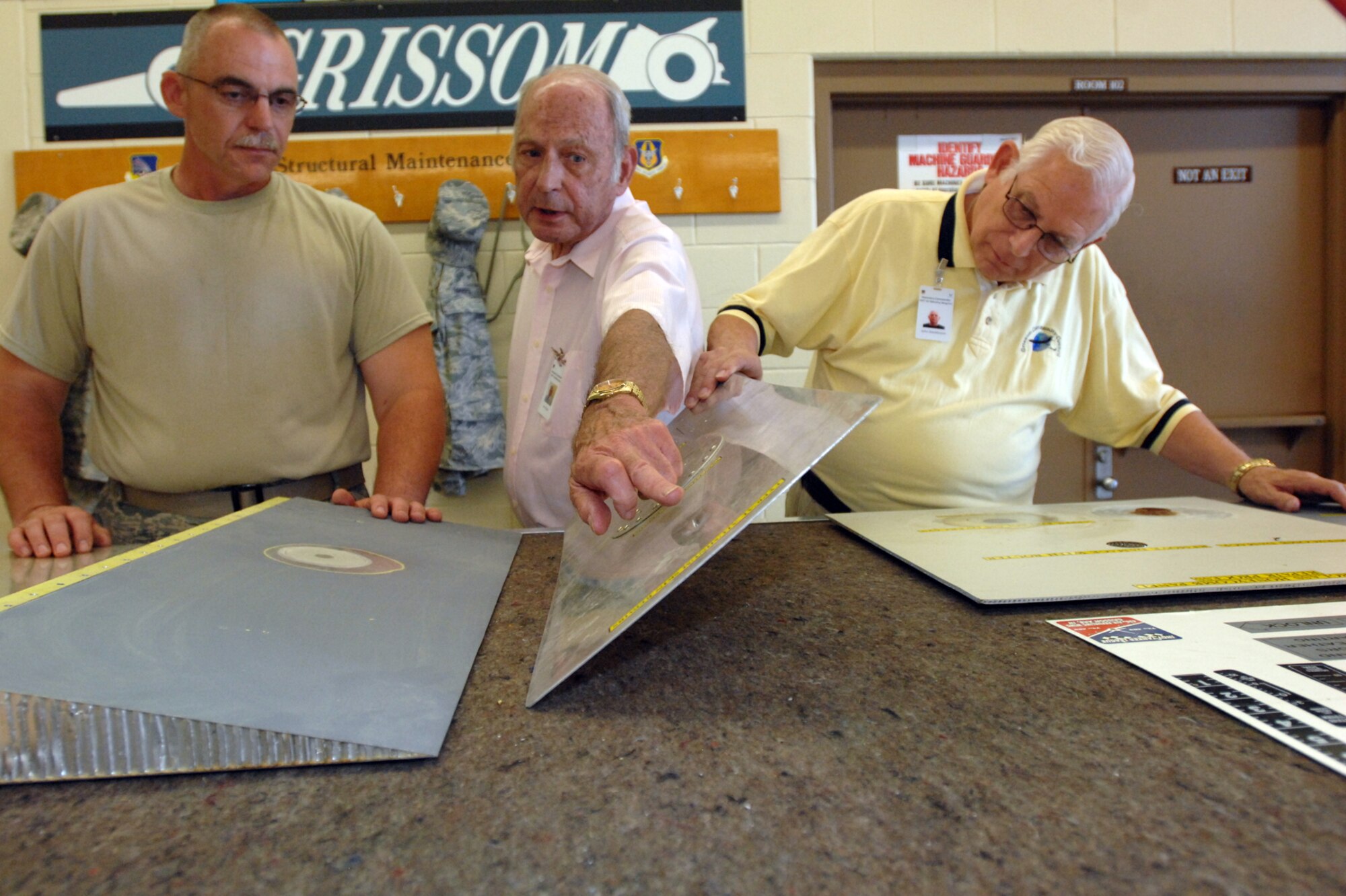 GRISSOM AIR RESERVE BASE, Ind. -- Tech. Sgt. James Goodman, left, a structural maintenance technician, shows John Gilpin, center, and John Stackhouse, both honorary commanders, examples of sheet metal repair procedures. The 434th Maintenance Group hosted three honorary commanders Aug. 19 to educate them on the maintainers' role in supporting the 434th Air Refueling Wing mission. (U.S. Air Force photo/Tech. Sgt. Douglas Hays)