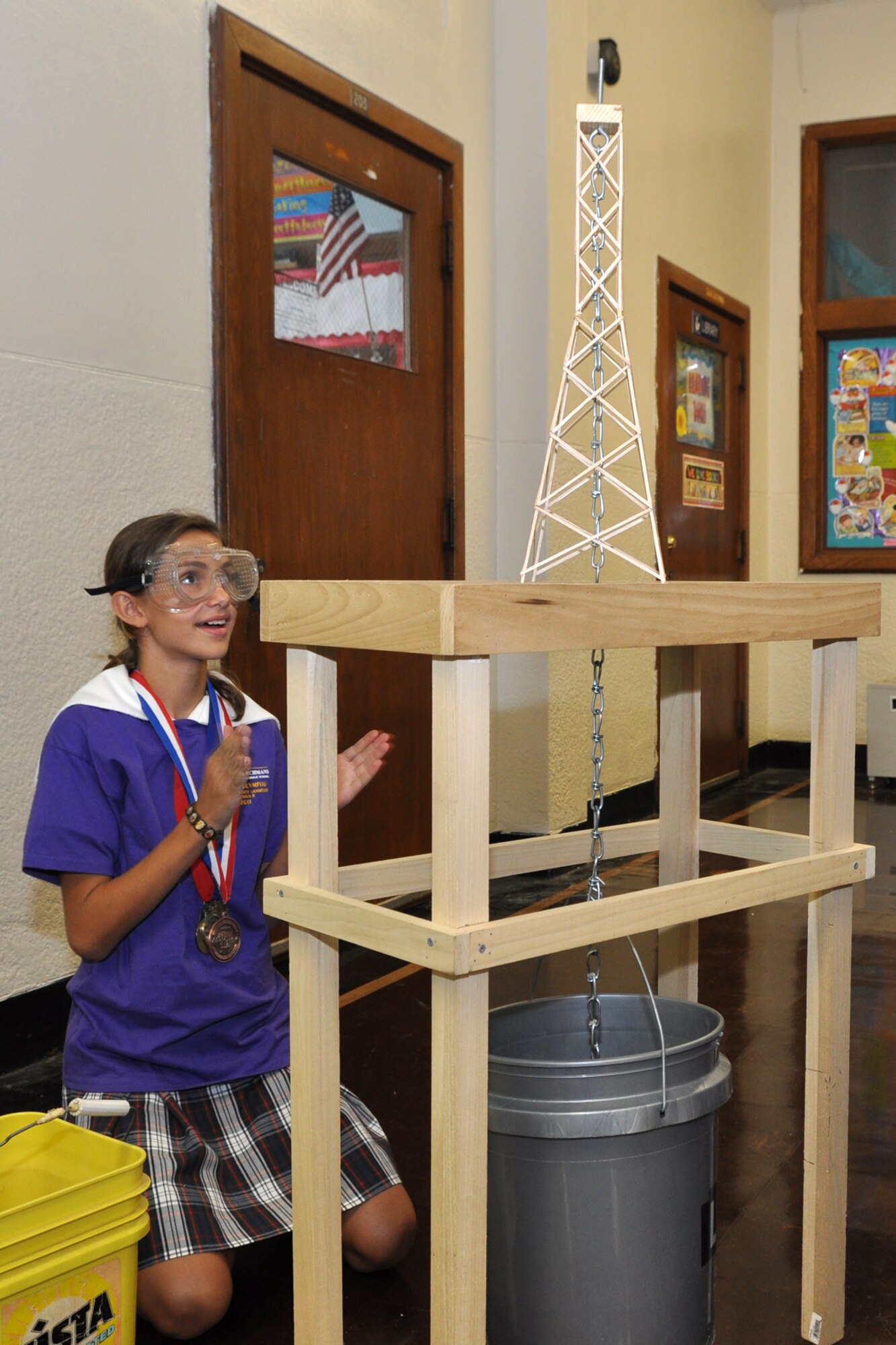 Marie Marcalus reacts positively to a failure during a demonstration at St. John Berchmans Catholic School in Shreveport, La., Aug. 17, 2011. The tower Marie was trying to collapse failed to do so even after all the sand available was poured into the bucket suspended below the tower on a chain. “Towers” is an exercise where balsawood towers constructed by students are put to a weight test to evaluate the strength of the construction and design, and how much weight it takes to collapse the tower. This tower, along with a smaller one, failed to collapse as expected with the large amount of sand added to the bucket. Instructors at the school decided to keep the towers in tact as examples of excellence. Marie is a student at the Catholic school, and participated in the STARBASE Louisiana program at Barksdale Air Force Base, La., when she was 5th Graders.  The STARBASE program, which is supported by the 307th Bomb Wing, presents an exciting 25-hour hands on/minds on aviation and aerospace curriculum to area 5th grade students and their teachers. The DoD program is committed to addressing the critical needs in STEM education - Science, Technology, Engineering and Mathematics. STARBASE Louisiana introduces its students to exciting STEM education topics, inspiring these young minds to further explore these topics in future course work. (Courtesy photo by Jeff Walston) 