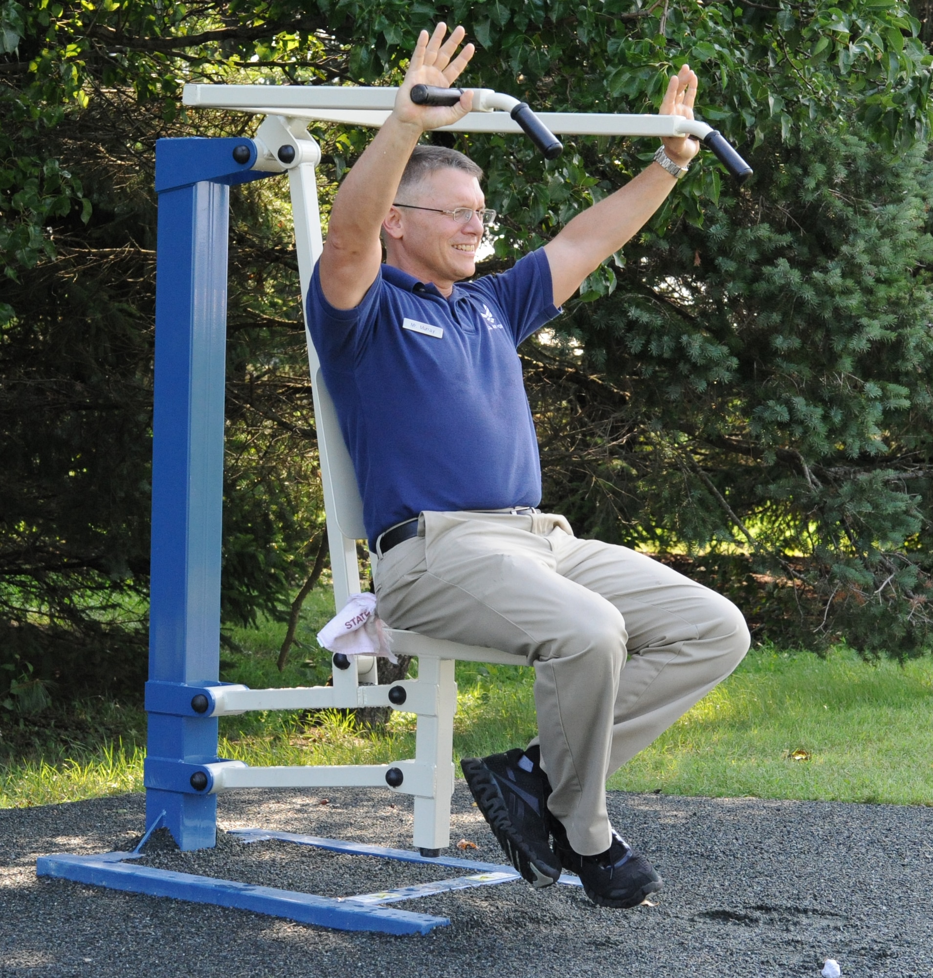 John Murray, a fitness program manager with the 436th Force Support Squadron, tests a new body-weight resistance machine on the running path Aug. 19.  The rowing machine is one of nine new machines set up along the running path behind The Landings Club to provide a better outdoor workout for service members.  (U.S. Air Force photo by Staff Sgt. Chad Padgett)