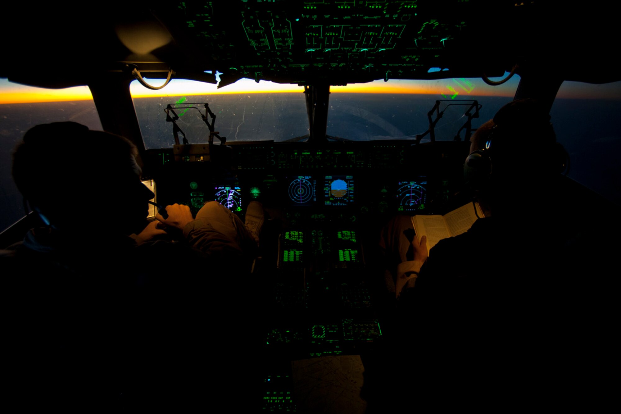 Capts. Matt Hammerle, left, and Eric Bowers, 817th Expeditionary Airlift Squadron pilots, reference flight material onboard a C-17 Globemaster III aircraft Aug. 18, 2011, while flying over Afghanistan. The crew transported equipment and supplies from Incirlik Air Base, Turkey, to Kandahar Air Field, Afghanistan. (U.S. Air Force photo by Tech. Sgt. Michael B. Keller/Released)