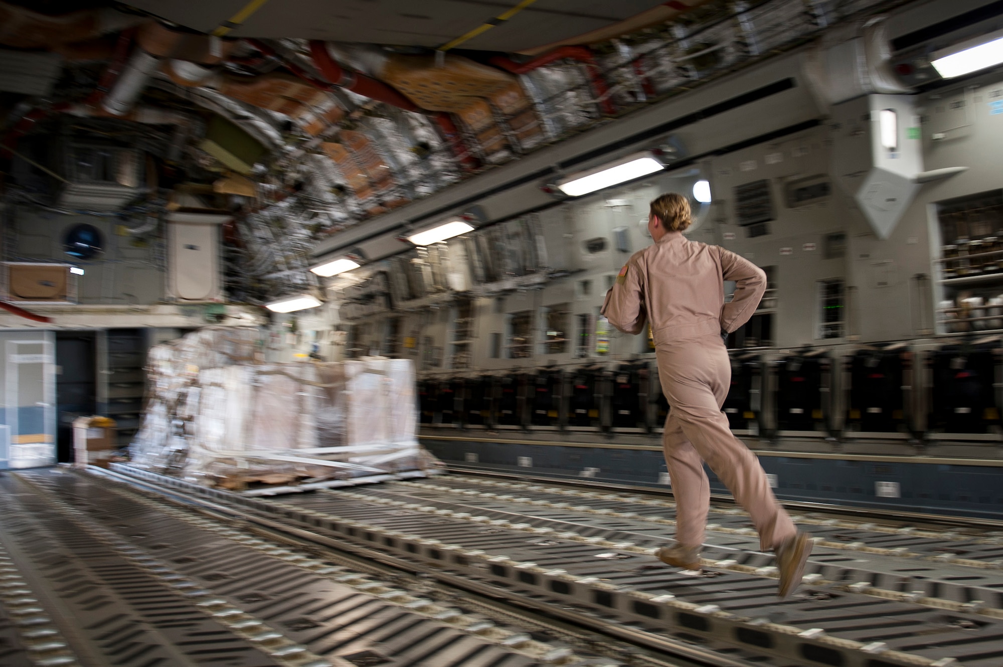 Staff Sgt. Melissa Butterfield, an 817th Expeditionary Airlift Squadron loadmaster, hurries to a pallet of cargo while unloading a C-17 Globemaster III aircraft Aug. 18, 2011, at Kandahar Air Field, Afghanistan, during a mission to transport equipment and supplies from Incirlik Air Base, Turkey. Loadmasters not only ensure the cargo is properly secured during flight, but also help with the unloading. (U.S. Air Force photo by Tech. Sgt. Michael B. Keller/Released)