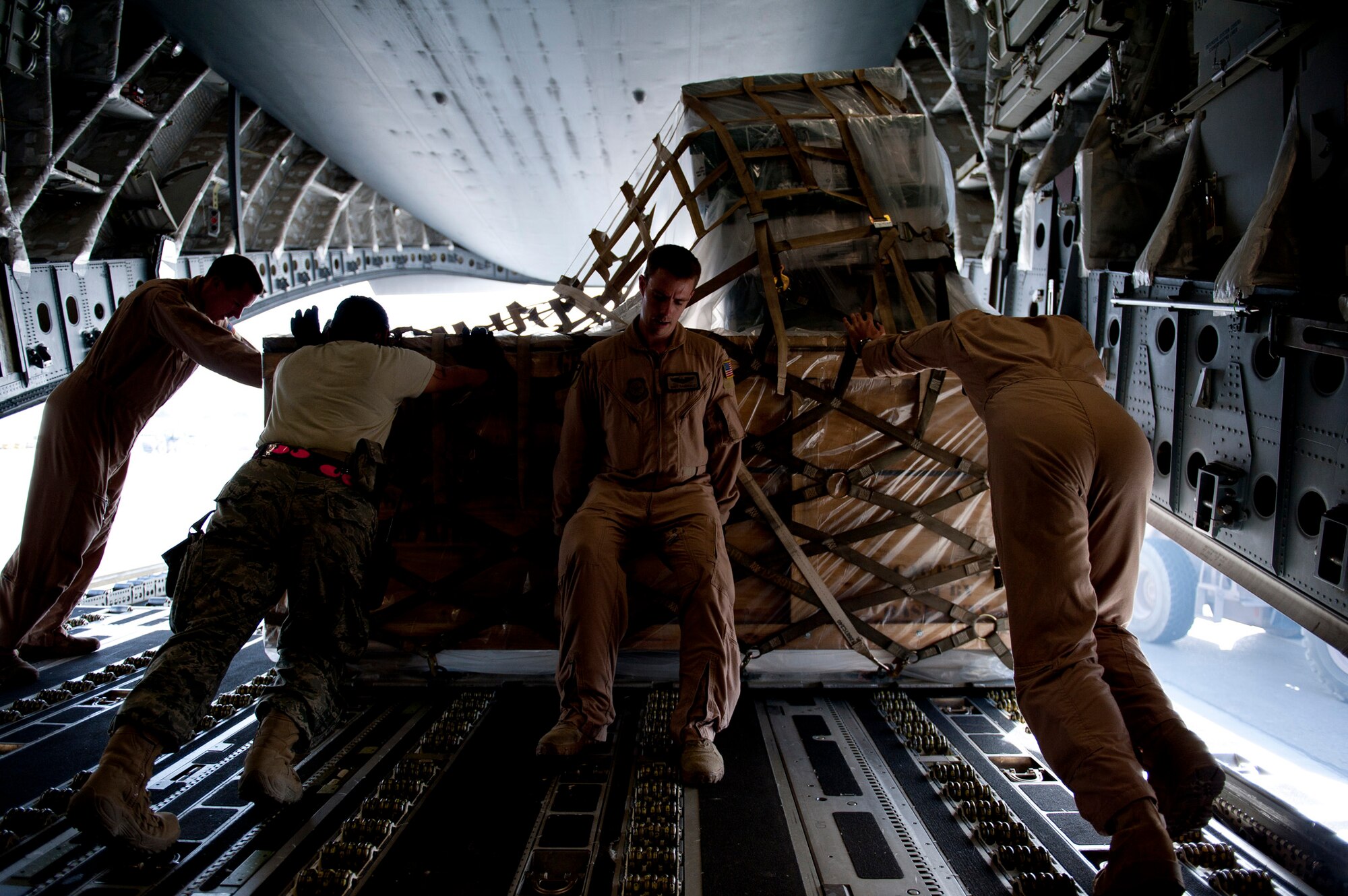 An 817th Expeditionary Airlift Squadron aircrew and 451st Expeditionary Logistics Readiness Squadron aerial port flight members unload a C-17 Globemaster III aircraft Aug. 18, 2011, at Kandahar Air Field, Afghanistan. The 817th EAS crew transported equipment and supplies from Incirlik Air Base, Turkey. (U.S. Air Force photo by Tech. Sgt. Michael B. Keller/Released)