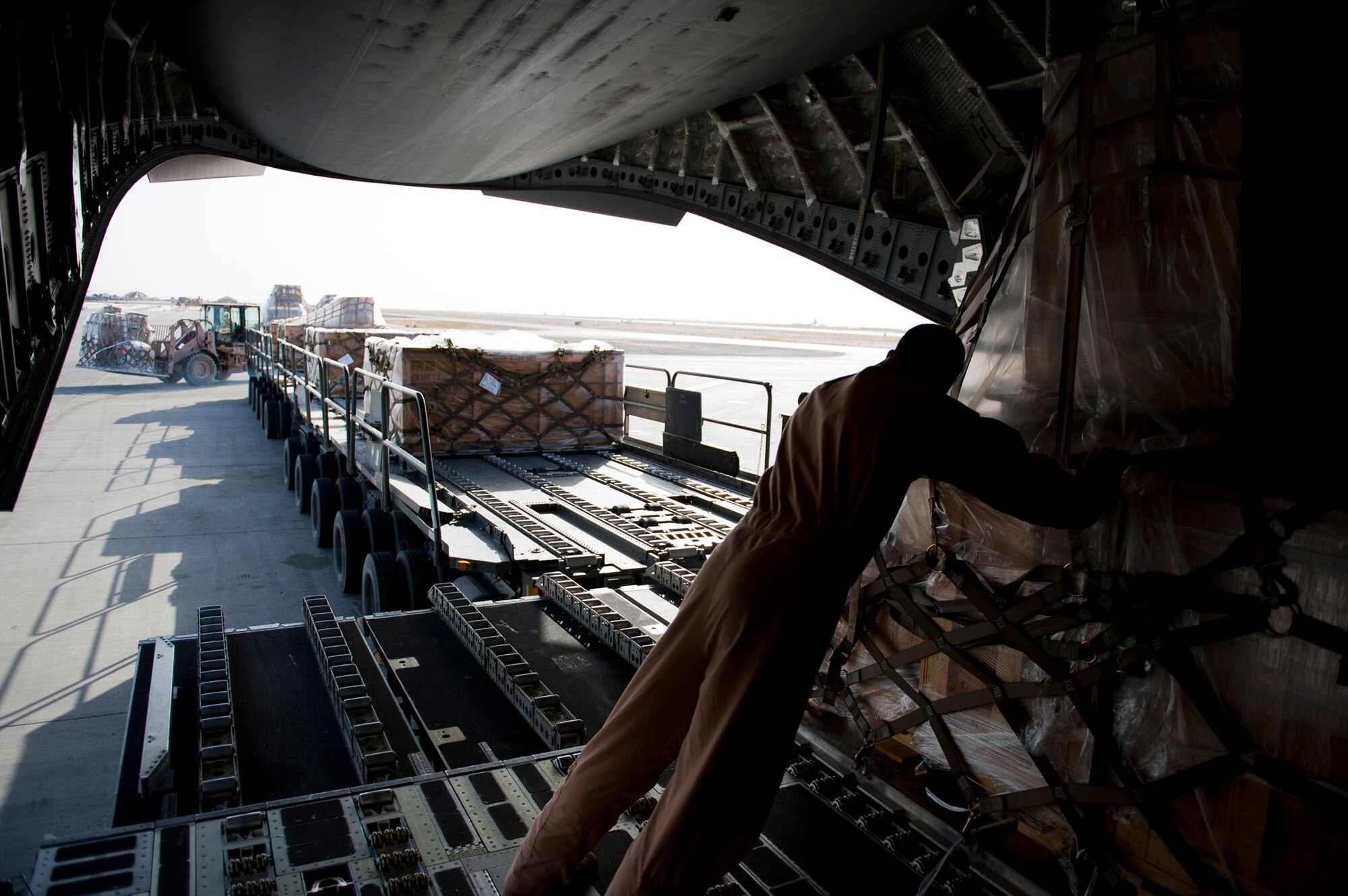 Staff Sgt. Sean Sullivan, an 817th Expeditionary Airlift Squadron loadmaster, pushes cargo while unloading a C-17 Globemaster III aircraft Aug. 18, 2011, at Kandahar Air Field, Afghanistan, during a mission to transport equipment and supplies from Incirlik Air Base, Turkey. Loadmasters not only ensure the cargo is properly secured during flight, but also help with the unloading. (U.S. Air Force photo by Tech. Sgt. Michael B. Keller/Released)