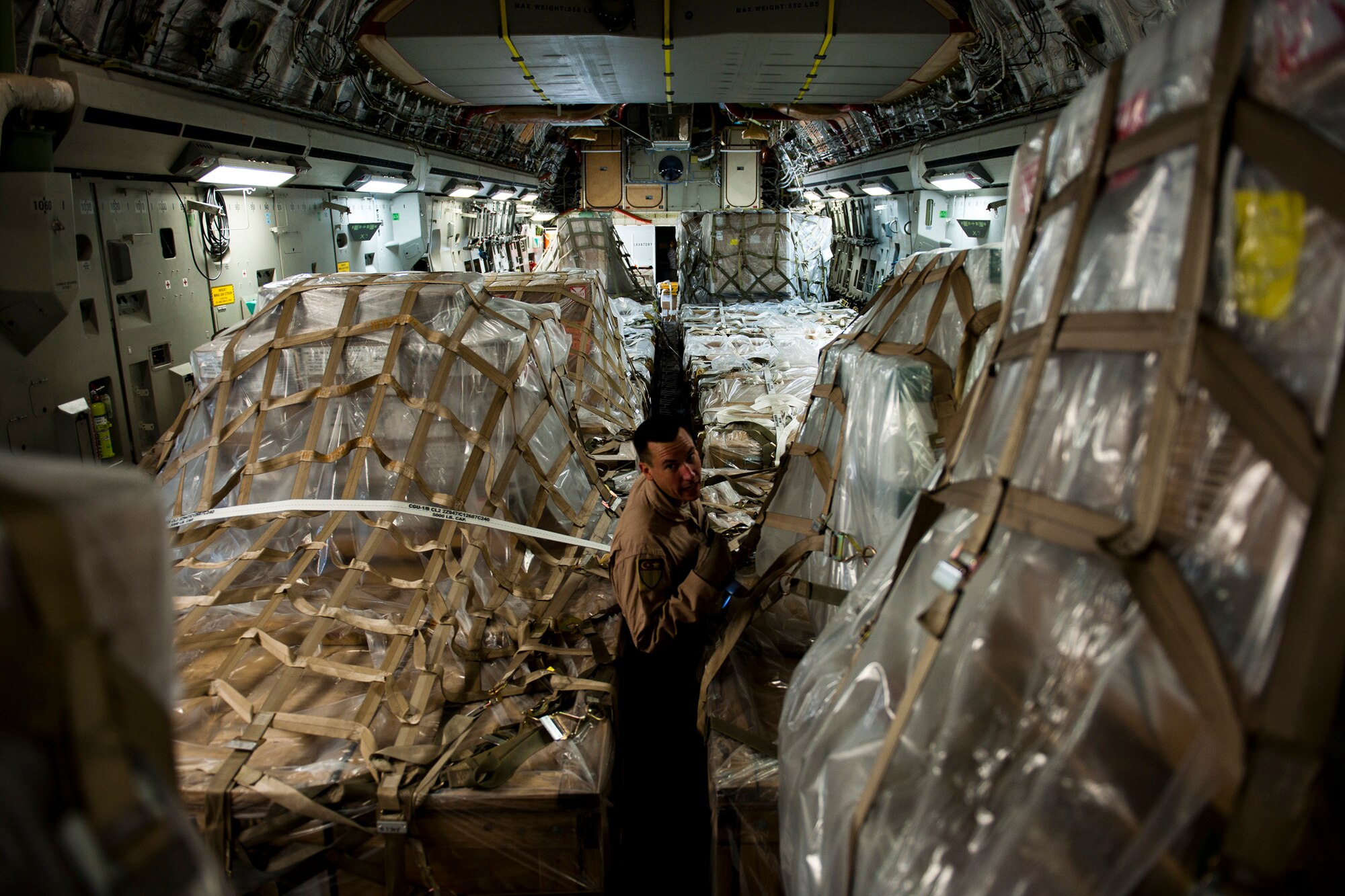 Staff Sgt. Sean Sullivan, an 817th Expeditionary Airlift Squadron loadmaster, inspects cargo onboard a C-17 Globemaster III aircraft Aug. 18, 2011, at Incirlik Air Base, Turkey, prior to a mission to transport equipment and supplies to Kandahar Air Field, Afghanistan. Loadmasters ensure the cargo is properly secured to prevent movement during flight. (U.S. Air Force photo by Tech. Sgt. Michael B. Keller/Released)