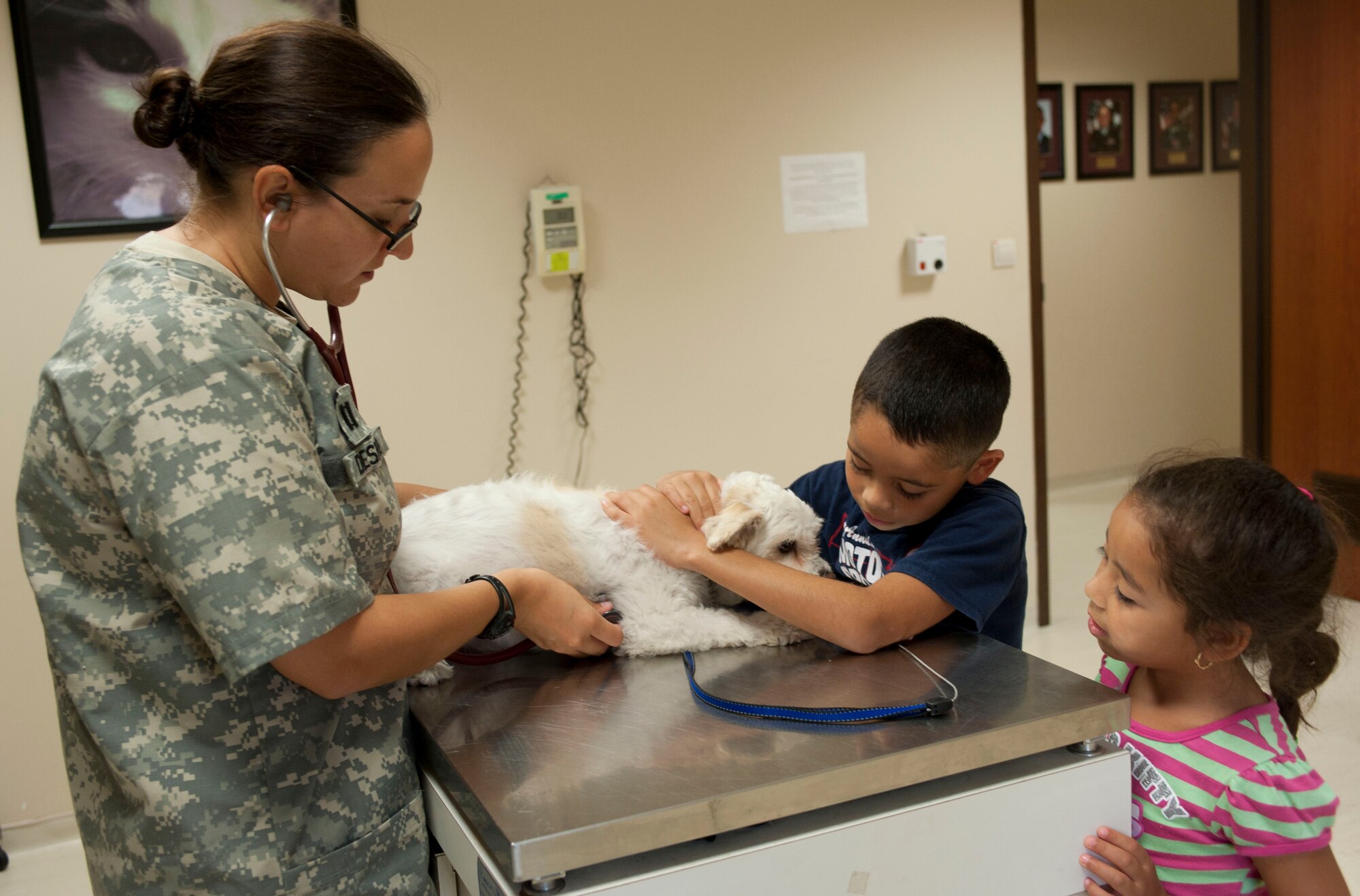 The children of Senior Master Sgt. Ray Saavedra, 39th Security Forces Squadron, watch as Army Capt. Tacia Despo, Incirlik Air Base Veterinarian, checks their dog's heart rate Aug. 18, 2011, at Incirlik, Turkey.(U.S. Air Force photo by Airman 1st Class Clayton Lenhardt/Released)