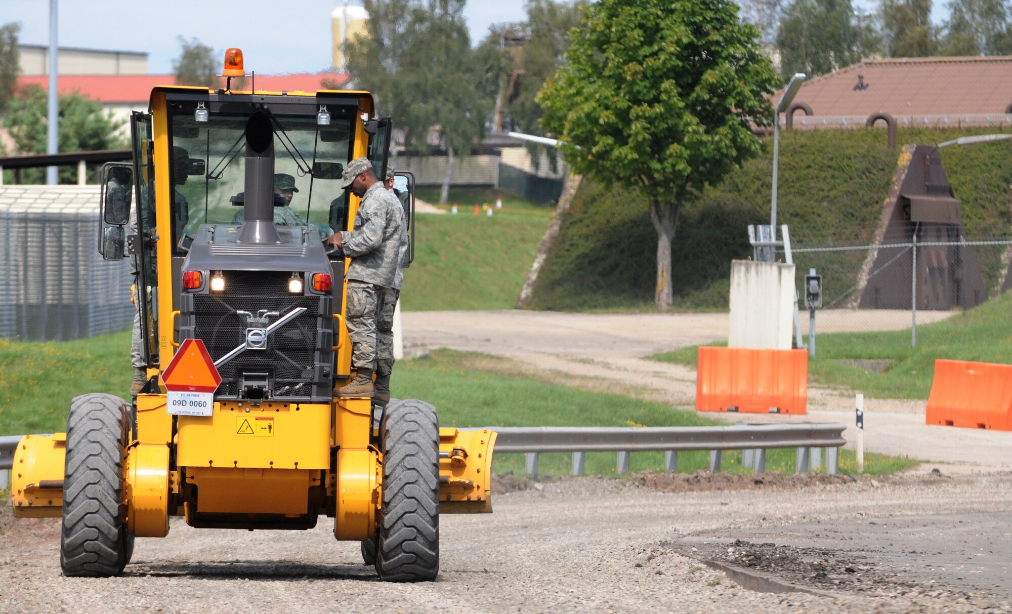 SPANGDAHLEM AIR BASE, Germany – Pavement and equipment Airmen from the 52nd Civil Engineer Squadron use a road grader to clear a road in preparation for road repairs here Aug 16. Pavement and equipment Airmen are combat engineers who train continuously to perform a variety of maintenance projects. The projects, which include airfield sweeping, road maintenance and snow removal, ensure Sabers and their families can drive safely on base. (U.S. Air Force photo/Senior Airman Nick Wilson)