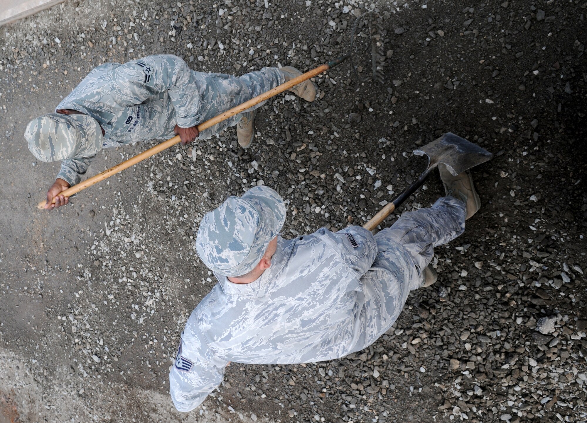 SPANGDAHLEM AIR BASE, Germany – Staff Sgt. Don Cederlund, left,  52nd Civil Engineer Squadron pavement and equipment craftsman, and Airman 1st Class Thomas Wilson, 52nd CES pavement and equipment apprentice, clear a road in preparation for road repairs here Aug 16. Pavement and equipment Airmen are combat engineers who train continuously to perform a variety of  maintenance projects. The projects, which include airfield sweeping, road maintenance and snow removal, ensure Sabers and their families can drive safely on base. (U.S. Air Force photo/Senior Airman Nick Wilson)