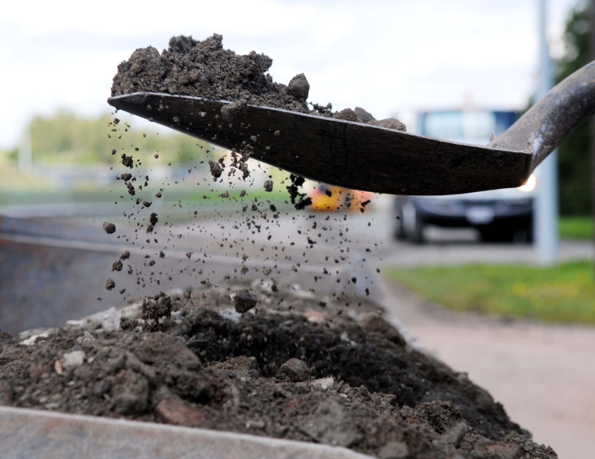 SPANGDAHLEM AIR BASE, Germany – A pavement and equipment Airman from the 52nd Civil Engineer Squadron shovels dirt to clear a road in preparation for road repairs here Aug 16. Pavement and equipment Airmen are combat engineers who train continuously to perform a variety of maintenance projects. The projects, which include airfield sweeping, road maintenance and snow removal, ensure Sabers and their families can drive safely on base. (U.S. Air Force photo/Senior Airman Nick Wilson)