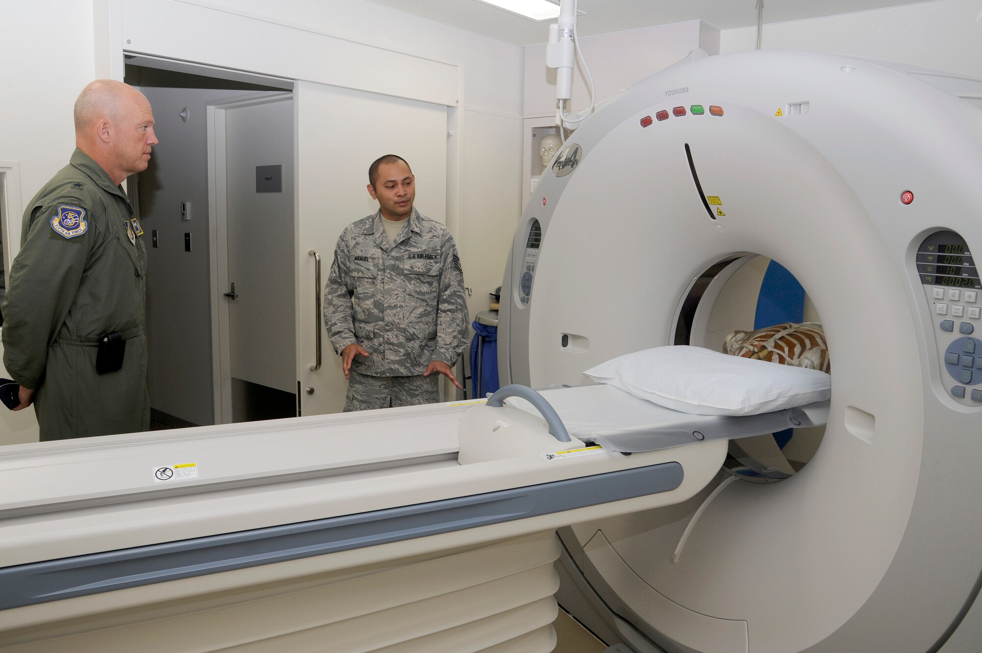 MISAWA AIR BASE, Japan -- Brig. Gen. John Raymond, left, 5th Air Force vice commander, receives a briefing from Tech. Sgt. Silber Manuel, 35th Medical Surgical Squadron, on the new CT scanner in the radiology department Aug. 19. The new CT scanner was a $1.1 million project and is a first for the department. (U.S. Air Force photo/Tech. Sgt. Marie Brown)