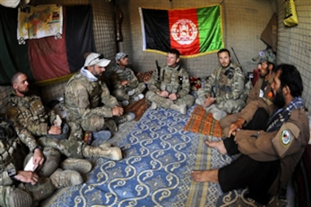 U.S. Navy Lt. Patrick King (center) and members of a U.S. Army team specializing in civil affairs and psychological operations meet with Afghan police in the village of Khani Kalay in the western Sarobi district in Afghanistan's Paktika province, on Aug. 16, 2011.  King is the Paktika Provincial Reconstruction Team Orgun Detachment operations officer.  