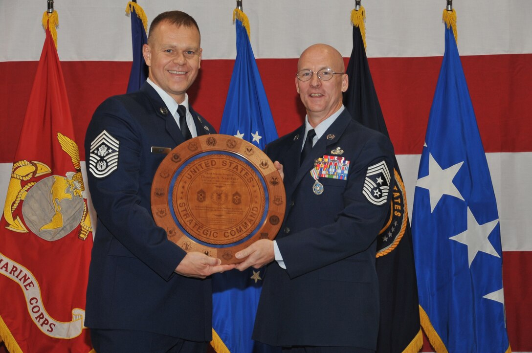 OFFUTT AIR FORCE BASE, Neb. - Chief Master Sgt. James Roy, Chief Master of the Air Force, presents Chief Master Sgt. Thomas Narofsky, U.S. Strategic Command's former senior enlisted leader, with a plaque commemorating his service during a change-of-responsibility and retirement ceremony Aug. 19.