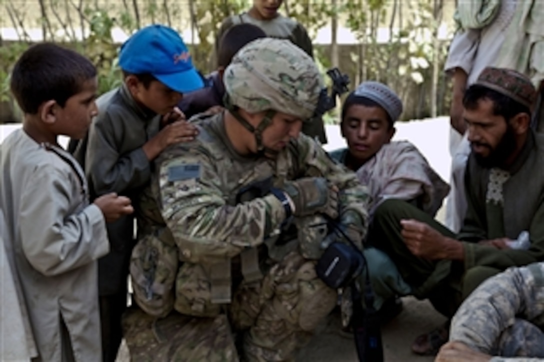 A U.S. soldier shows Afghan citizens his camera outside of Combat Outpost Caren in Afghanistan, Aug. 14, 2011. The soldier is assigned to the 4th Infantry Division.