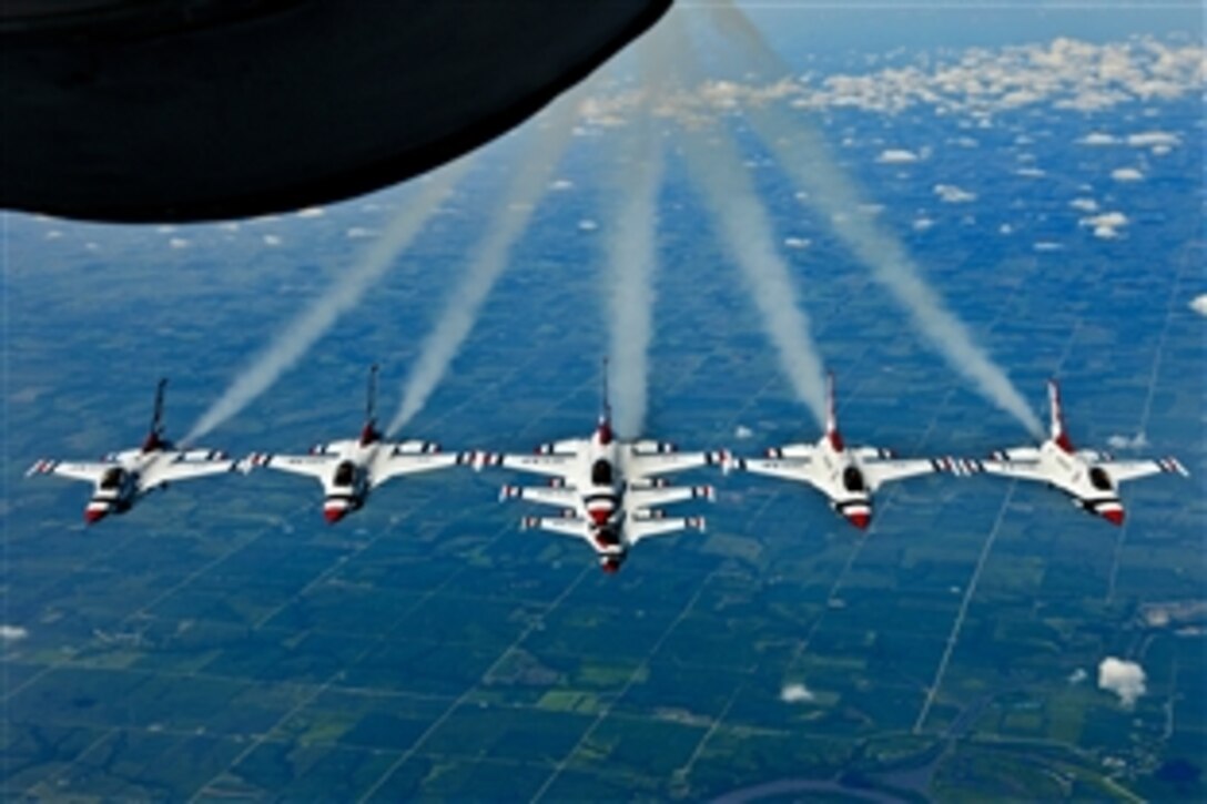 Air Force pilots fly their F-16 Fighting Falcons in formation during a refueling mission over the Midwest while enroute to an air show in Portsmouth, N.H., Aug. 11, 2011. The  KC-135R Statotanker and its crew are from the 157th Air Refueling Wing at Pease Air National Guard Base, N.H. The F-16s are part of the Air Force's flight demonstration squadron.