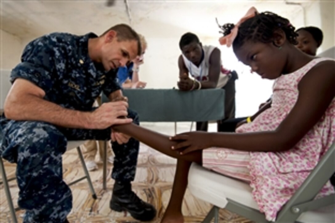 U.S. Navy Lt. Cmdr. Timothy Mickel examines a patient at the Killick Haitian Coast Guard Base surgical screening site during Continuing Promise 2011 in Port-au-Prince, Haiti, Aug. 18, 2011. Continuing Promise is a five-month humanitarian assistance mission to the Caribbean, Central and South America.
