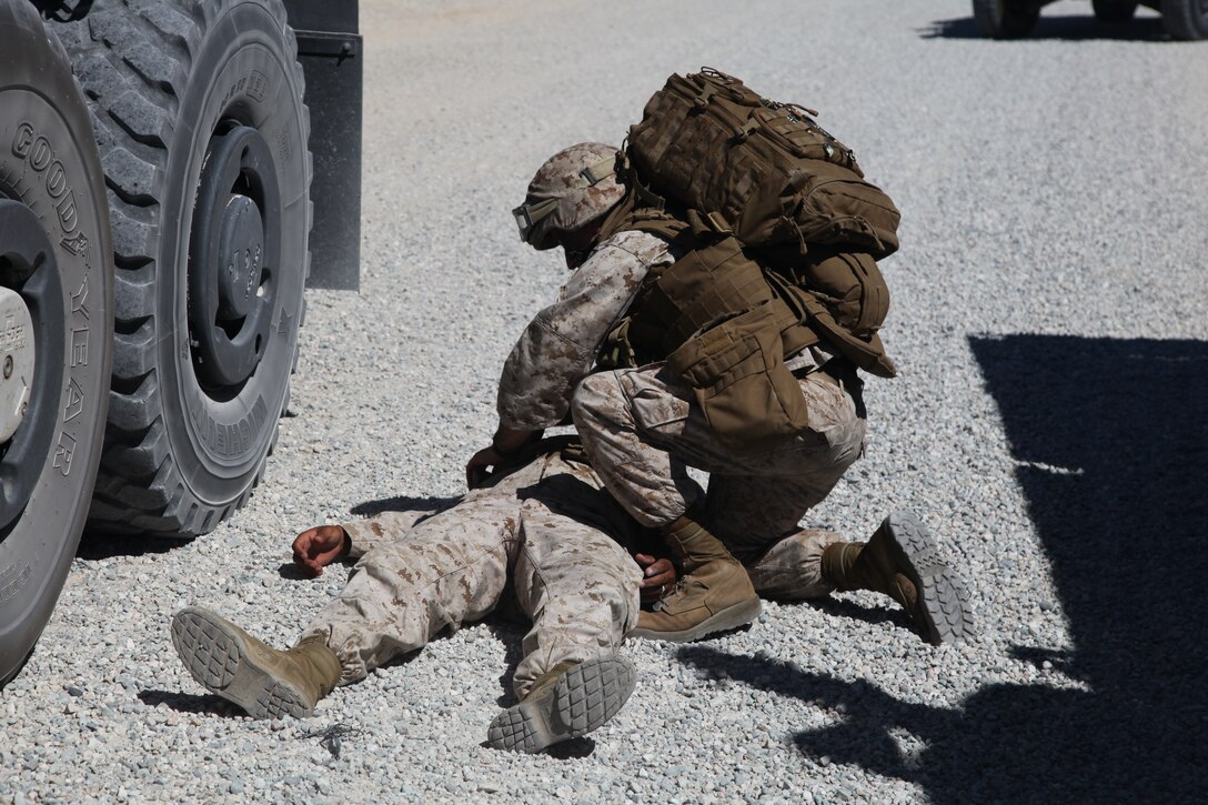 Petty Officer 3rd Class Niko Lunetta, corpsman, Headquarters and Support Company, Combat Logistics Battalion 7, 1st Marine Logistics Group, performs medical attention to a simulated casualty of an improvised explosive device during a training convoy at Marine Corps Air Ground Combat Center Twentynine Palms, Calif., Aug. 19.
