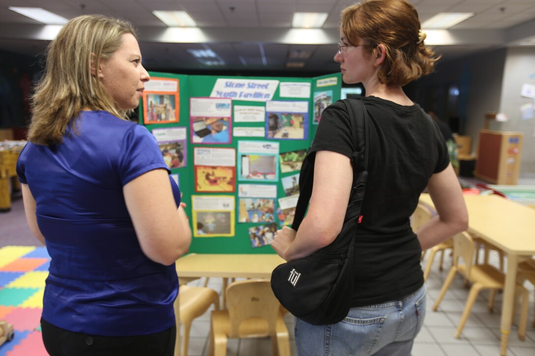 Jennifer Triolo, School Age Care program assistant leader, speaks with Ginnette Sawyer, attendant of the Stone Street Pavilion open house, about different clubs and activities offered by the program, Aug. 20. Sawyer is the mother of five-year old Tristan Sawyer who will be attending SAC during the upcoming school year.